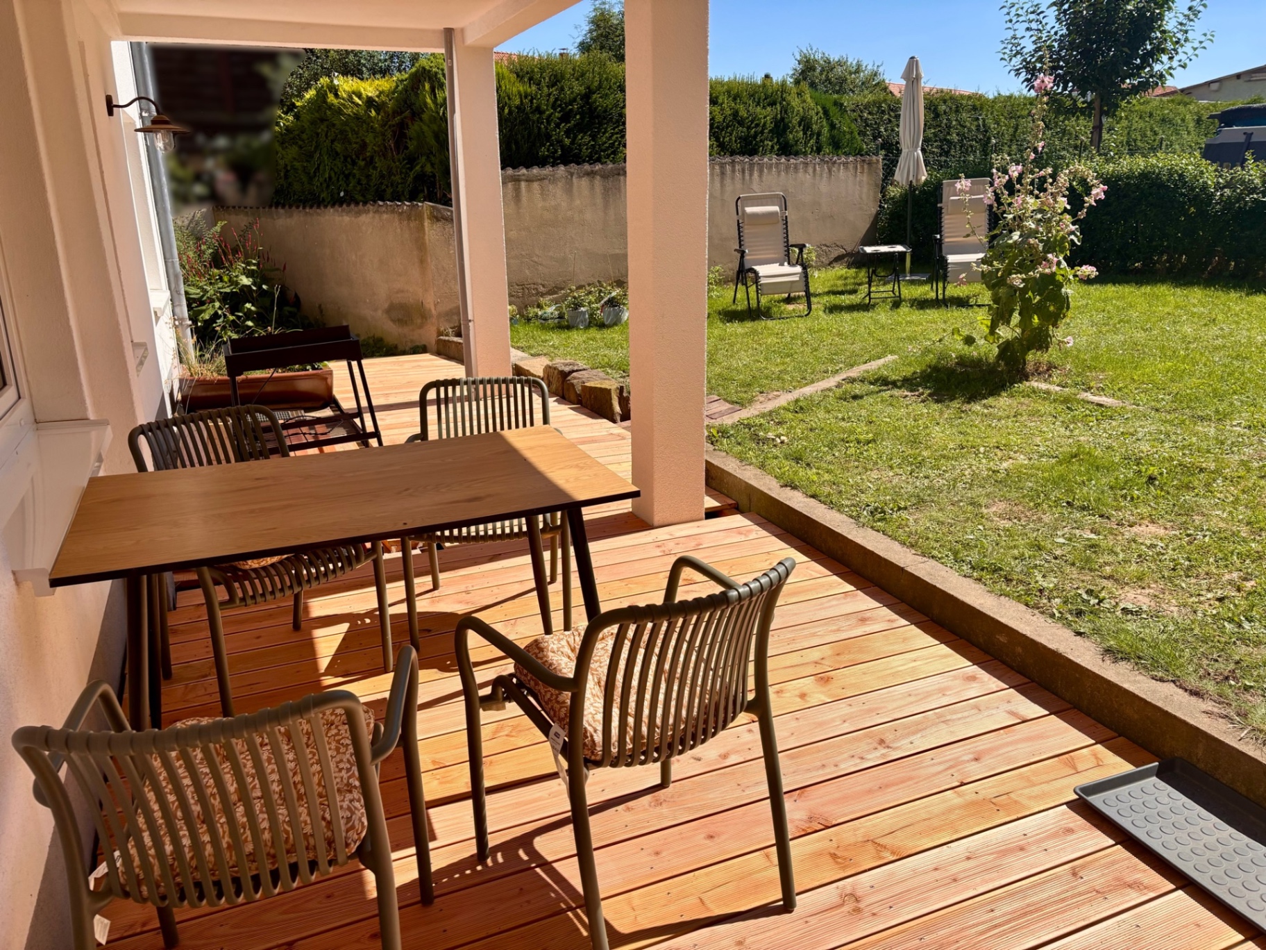 Überdachte Terrasse mit Esstisch und Blick in den Garten