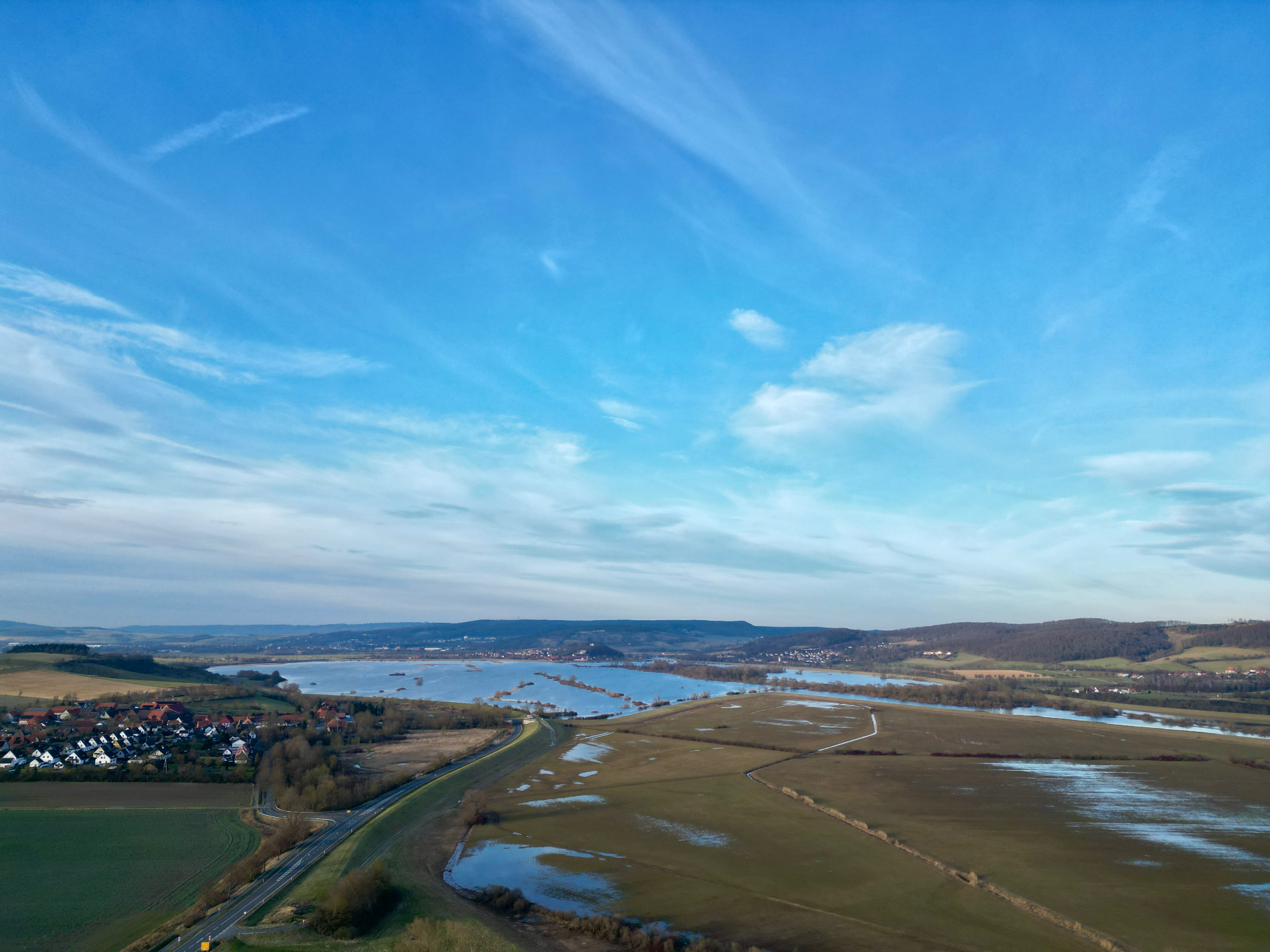Luftaufnahme des Leinepolders mit Wasserflächen und Leinebergland