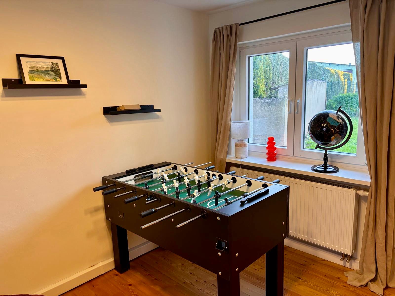 Spielzimmer mit Tischkicker und Gartenblick